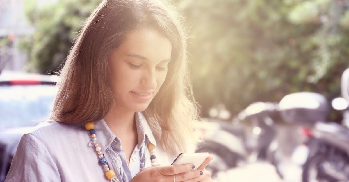 kvinne ser på mobiltelefon